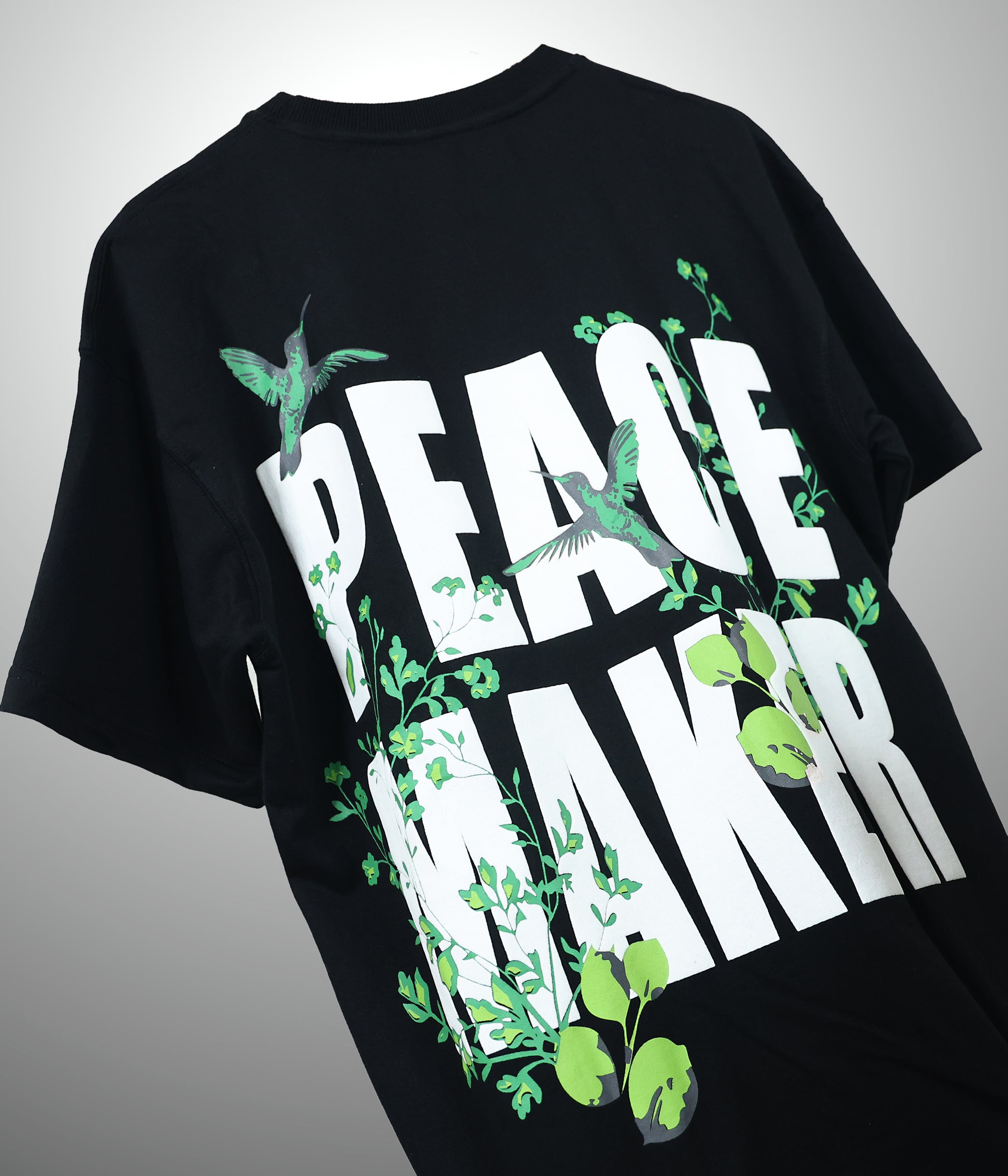 Black t-shirt with Peace maker written on it floating in the air 